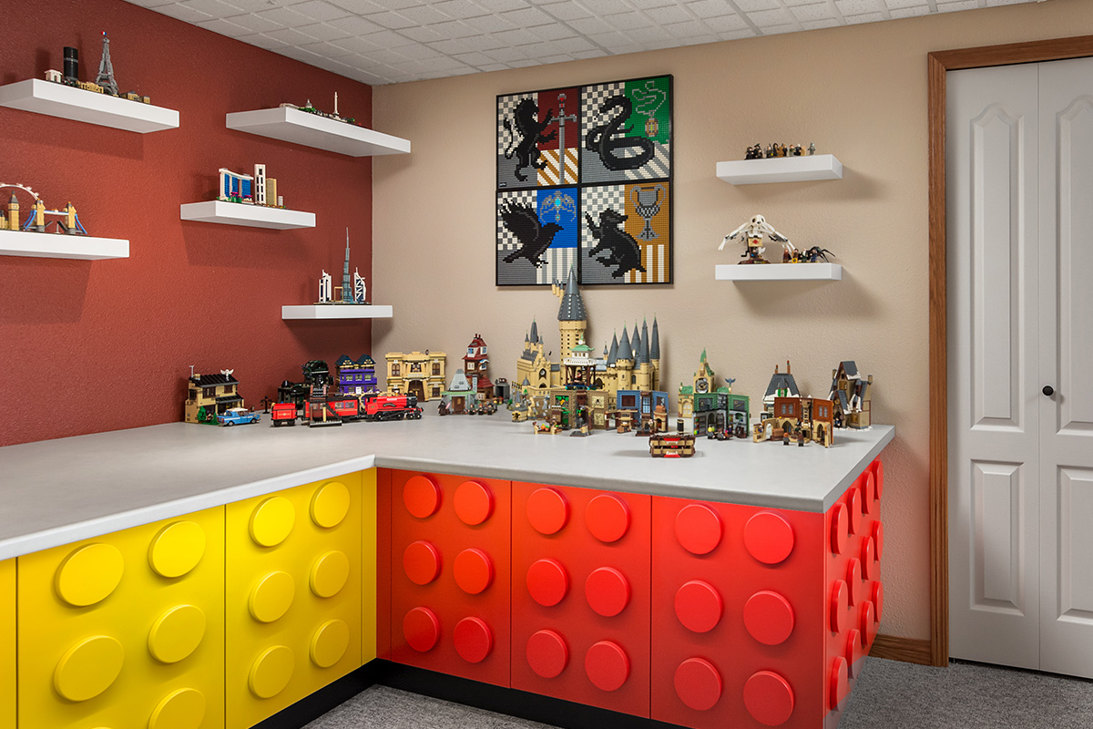 A room with multi-coloured cabinets doors made to look like Lego® blocks. Lego® creations sit on the countertop.