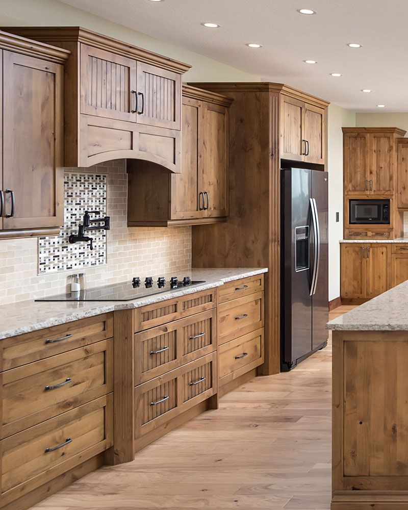 creative-kitchens-mb_portfolio-jeannot_02 A kitchen with knotty alder cabinets, with a mix of flat panel and beaded panel door styles.