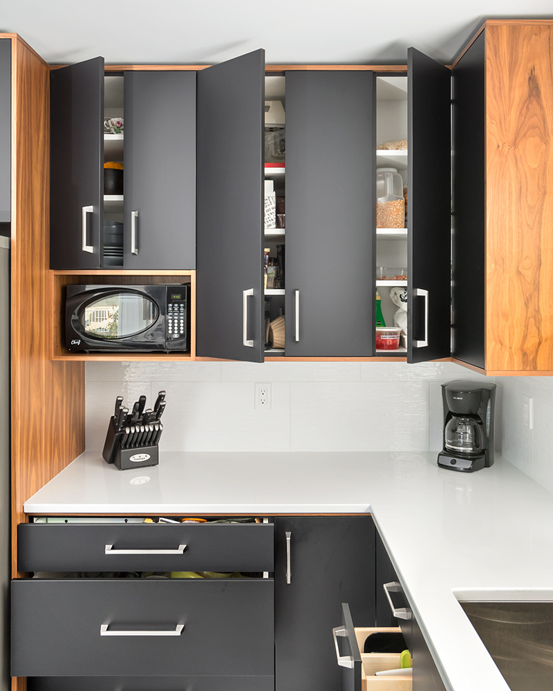 creative-kitchens-mb_portfolio-jeannot_02 A kitchen with laminate cabinets in two tones — black and woodgrain.